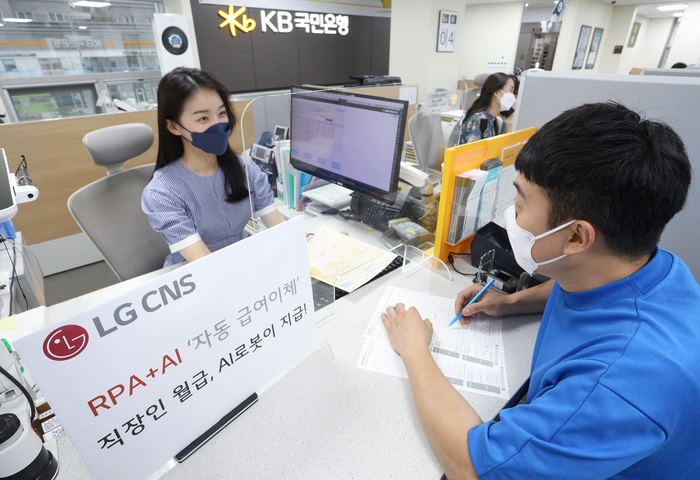 KB국민은행 영업점 직원이 급여이체 업무는 RPA와 AI에 맡기고, 고객상담 업무에 집중하고 있다. /사진제공=LG CNS