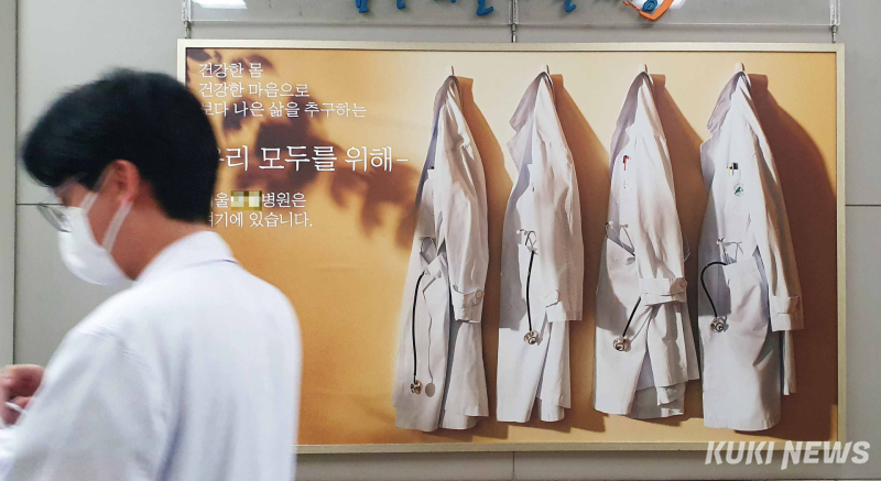 서울의 한 상급종합병원 로비에 걸린 병원 홍보물 옆으로 의료진이 이동하고 있다. 쿠키뉴스 자료사진